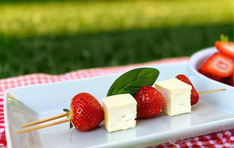 이색피크닉 요리법 - **Elegant Brie and Strawberry Skewers at Sunset Picnic:** A close-up, high-definition shot of delica...
